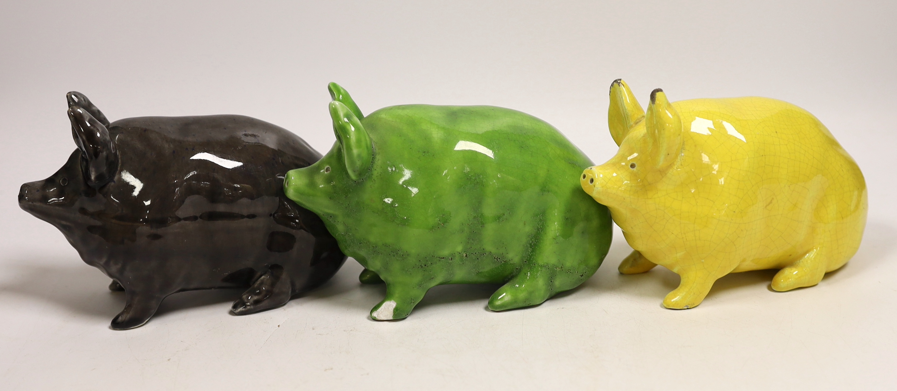 Three Wemyss ware pigs in green, yellow and black glazes, 15cm